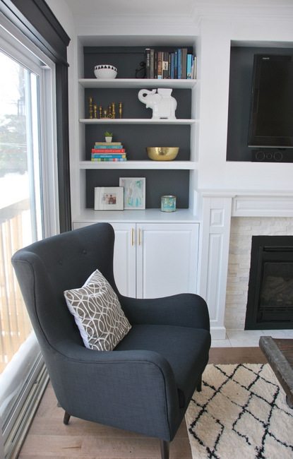 living room featuring black wingback chairs (the polo by structube) with fireplace built ins and grey couch - via the sweetest digs