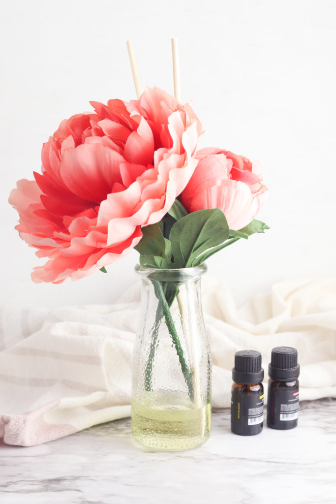 Make this DIY Flower Reed Diffuser for your essential oils. A cute Anthropologie hack to make your house smell amazing. Click for tutorial!