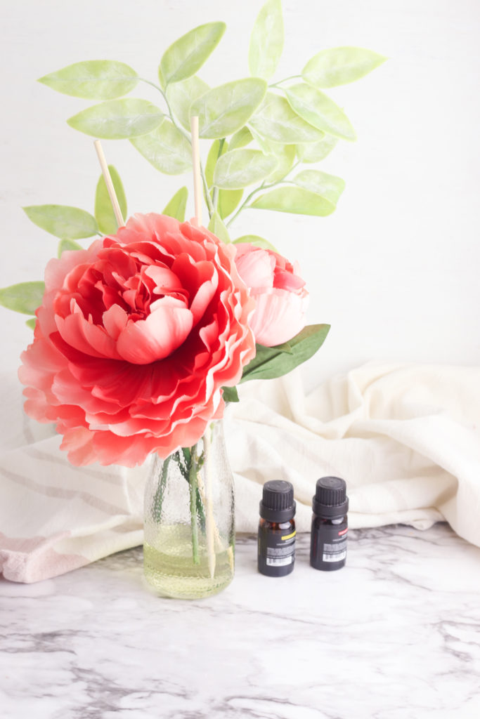 Make this DIY Flower Reed Diffuser for your essential oils. A cute Anthropologie hack to make your house smell amazing. Click for tutorial!