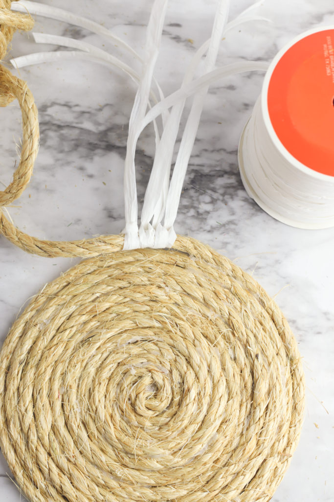 Adding raffia ribbon to the formed rope.