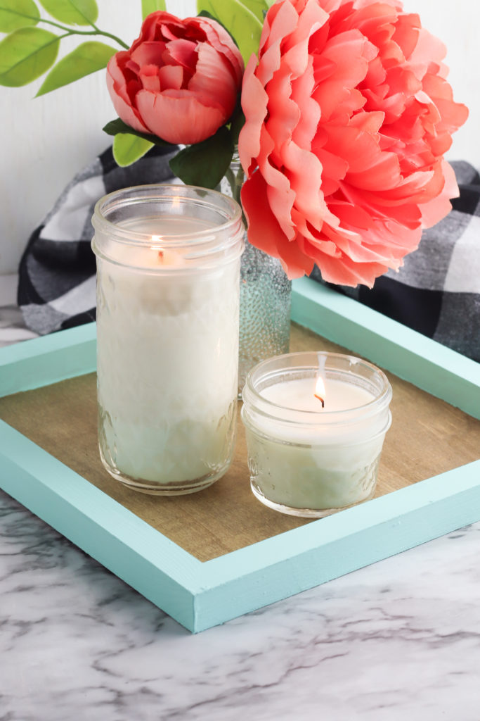 Painted wood tray decorated with candles and flowers.