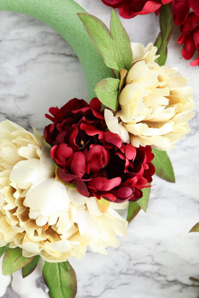 Attachez des fleurs de pivoines artificielles à la forme de couronne en mousse.